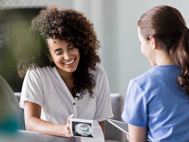 Woman looking at ultrasound photos